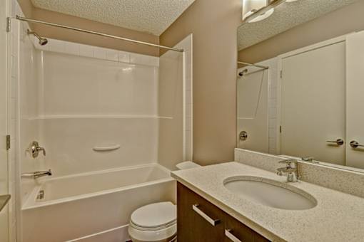 A white bathroom with a toilet, sink, and bathtub.