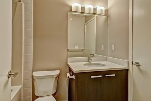 A bathroom with a white toilet, sink, and mirror.