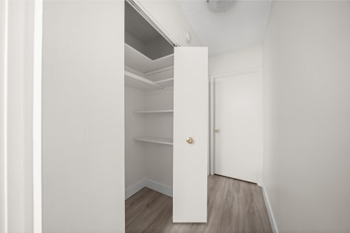 an empty closet in a room with white walls and wood floors