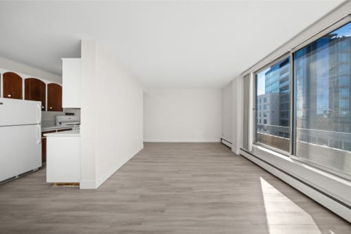 a spacious living room with large windows and a kitchen