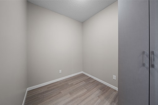 an empty room with wood flooring and white walls