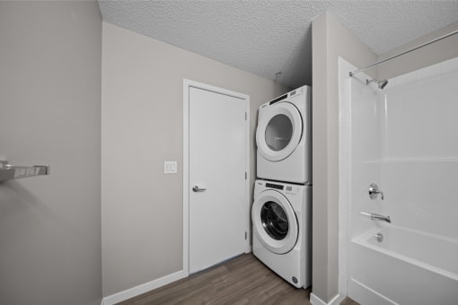 the living room has a washer and dryer and a door to the bathroom