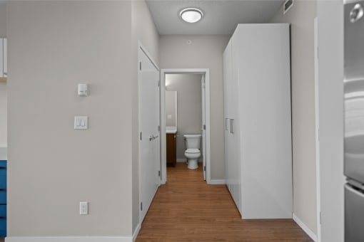 a corridor with white walls and a toilet in a bathroom