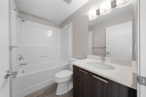 a bathroom with a toilet sink and shower and a mirror
