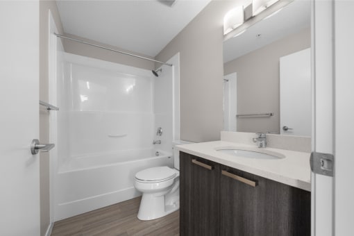 a bathroom with a toilet sink and shower and a mirror
