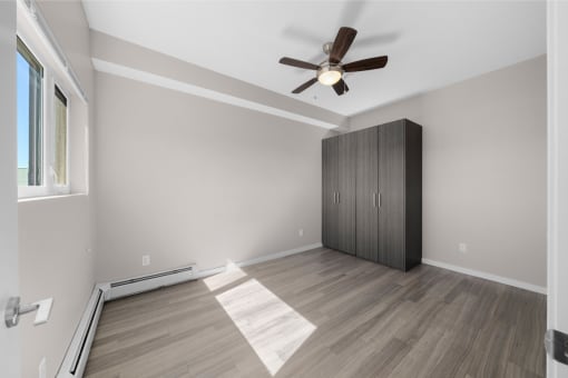 an empty room with a closet and a ceiling fan