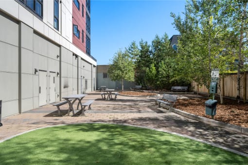 a courtyard with picnic tables and benches in front of a building