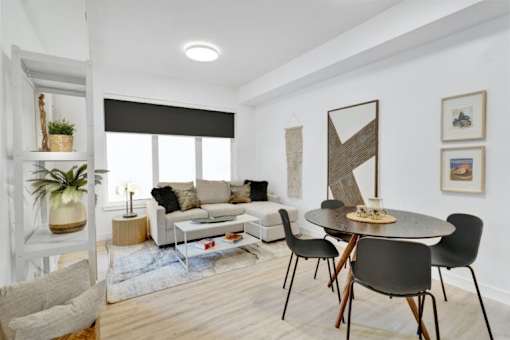 A living room with a black table and chairs.