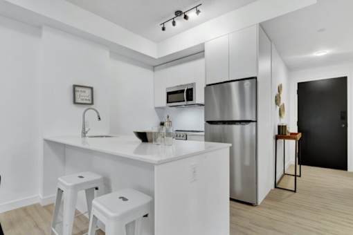 A modern kitchen with white cabinets and appliances.