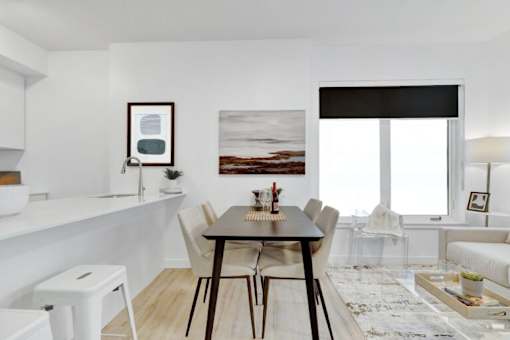 A modern dining room with a wooden table and chairs.