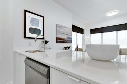 A modern kitchen with a white countertop and a dishwasher.