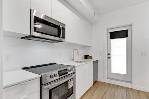 A kitchen with white appliances and cabinets.