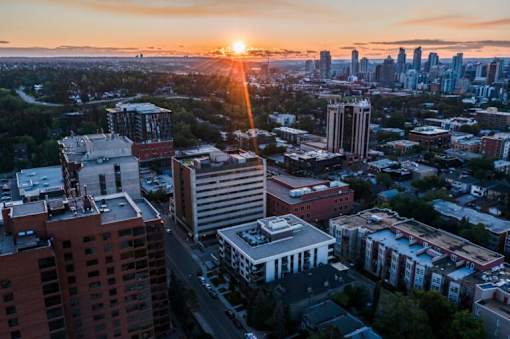 A cityscape with buildings and a sunset in the background.