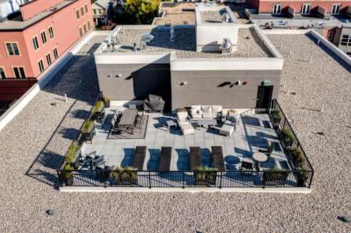 A rooftop patio with a table and chairs.