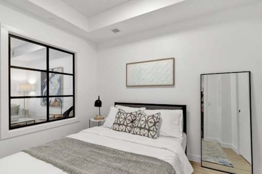 A bedroom with a large bed and a large mirror.