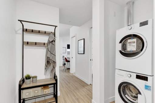 A white washing machine is in a small laundry room.