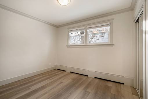 A room with a window and wooden flooring.