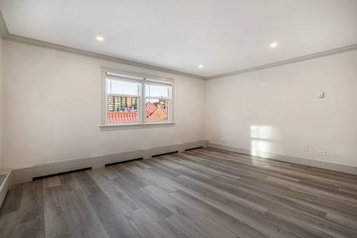 A room with a window and wooden flooring.