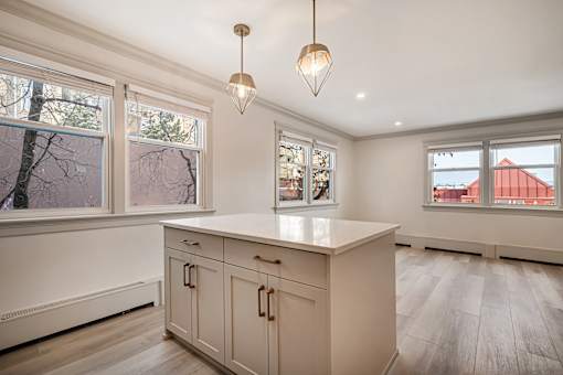 A kitchen with a white countertop and cabinets.