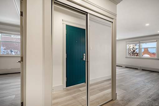 A room with a teal door and a white wall.