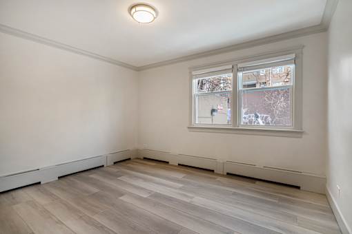 A room with a window showing a view of a tree.