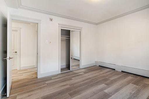 A room with a white wall and a wooden floor.