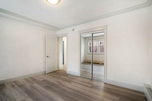 A room with a wooden floor and a sliding door.