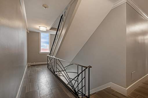 A staircase with a metal railing and wooden steps.