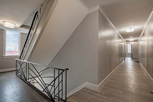 A long hallway with a staircase on the left side.