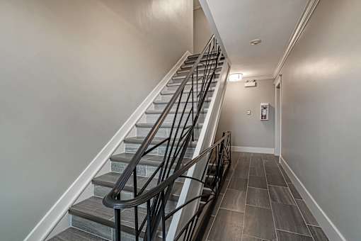 A staircase with a metal railing and wooden steps.
