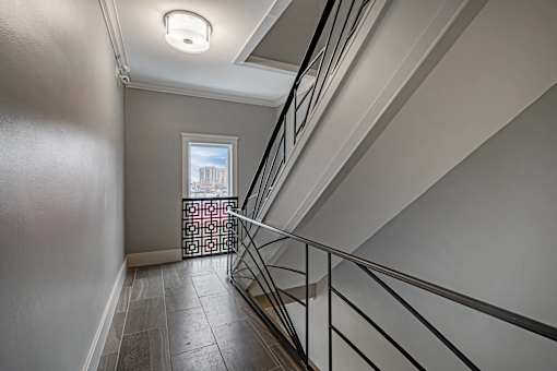 A staircase with a metal railing and a window in the background.