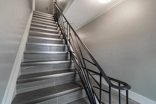 A staircase with a metal railing and wooden steps.