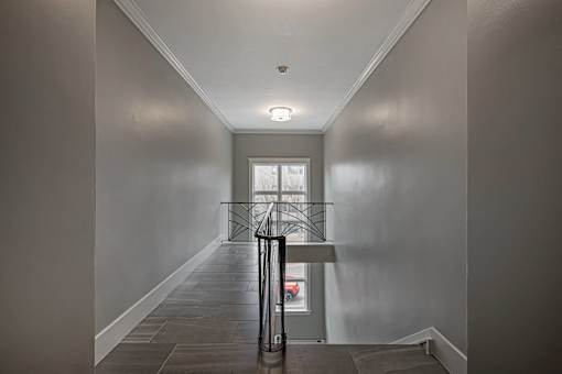A hallway with a black suitcase on the floor.
