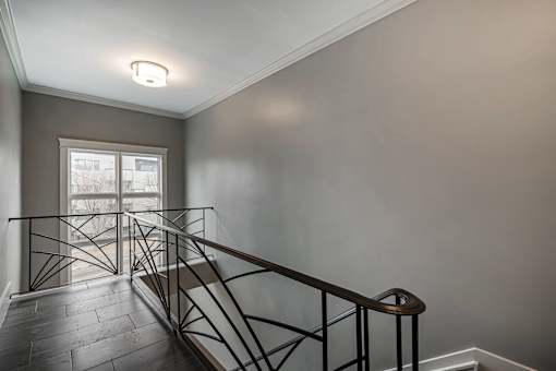 A staircase with a metal railing and wooden steps.