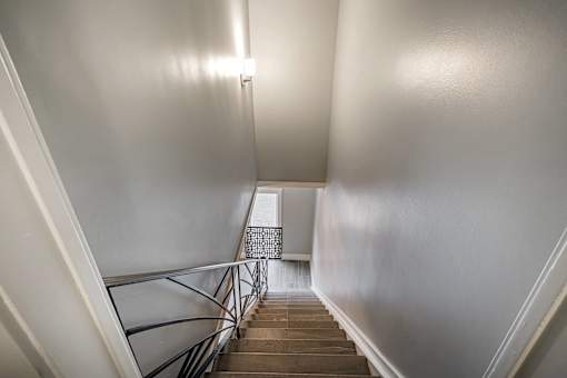 A staircase with a metal railing and wooden steps.