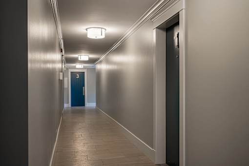 A long hallway with a blue door at the end.