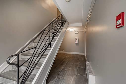 A staircase with a metal railing and wooden steps.