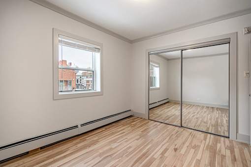 A room with a wooden floor and a large mirror.