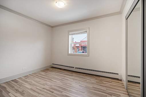 A room with a window and a wooden floor.