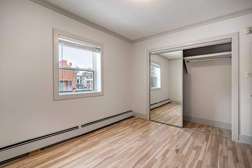 A room with wooden floors and a large mirror on the wall.
