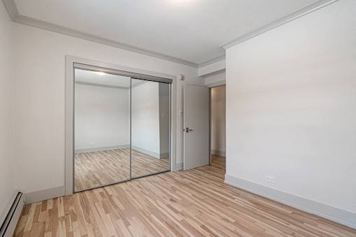 A room with a white wall and a wooden floor.