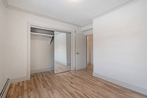 A room with a white wall and a wooden floor.