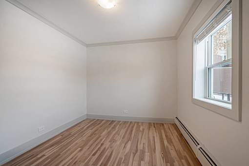 Empty room with wooden floor and a window.