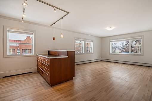 A room with a wooden floor and a brown desk.
