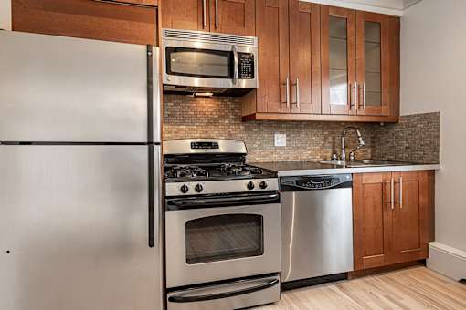A modern kitchen with a stainless steel refrigerator, oven, and microwave.