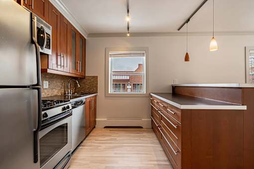 A kitchen with wooden cabinets and stainless steel appliances.