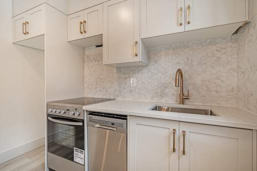 A kitchen with a stainless steel oven and sink.