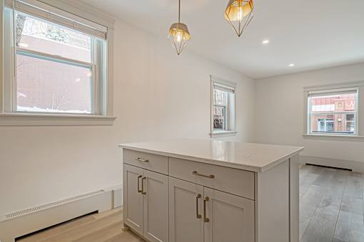 A kitchen with a white countertop and cabinets.