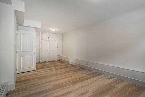 A room with wooden flooring and white walls.