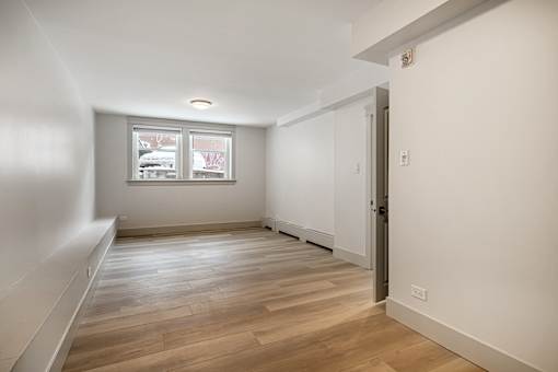 A room with wooden flooring and a window.